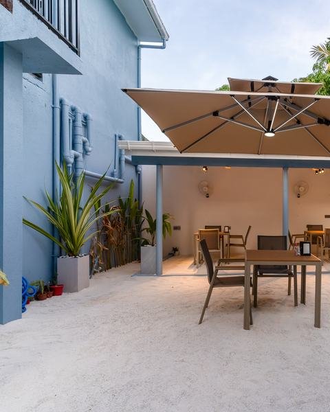 The courtyard at Madi Maldives, set for breakfast under a parasol.