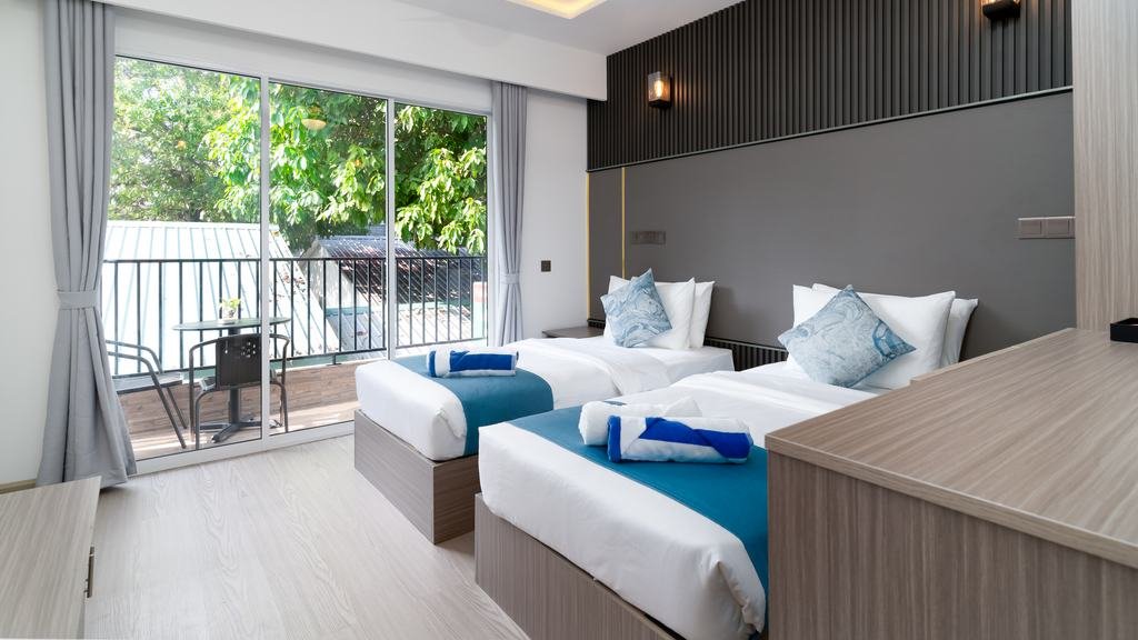 The room in full: twin beds turned down, the balcony along one side.